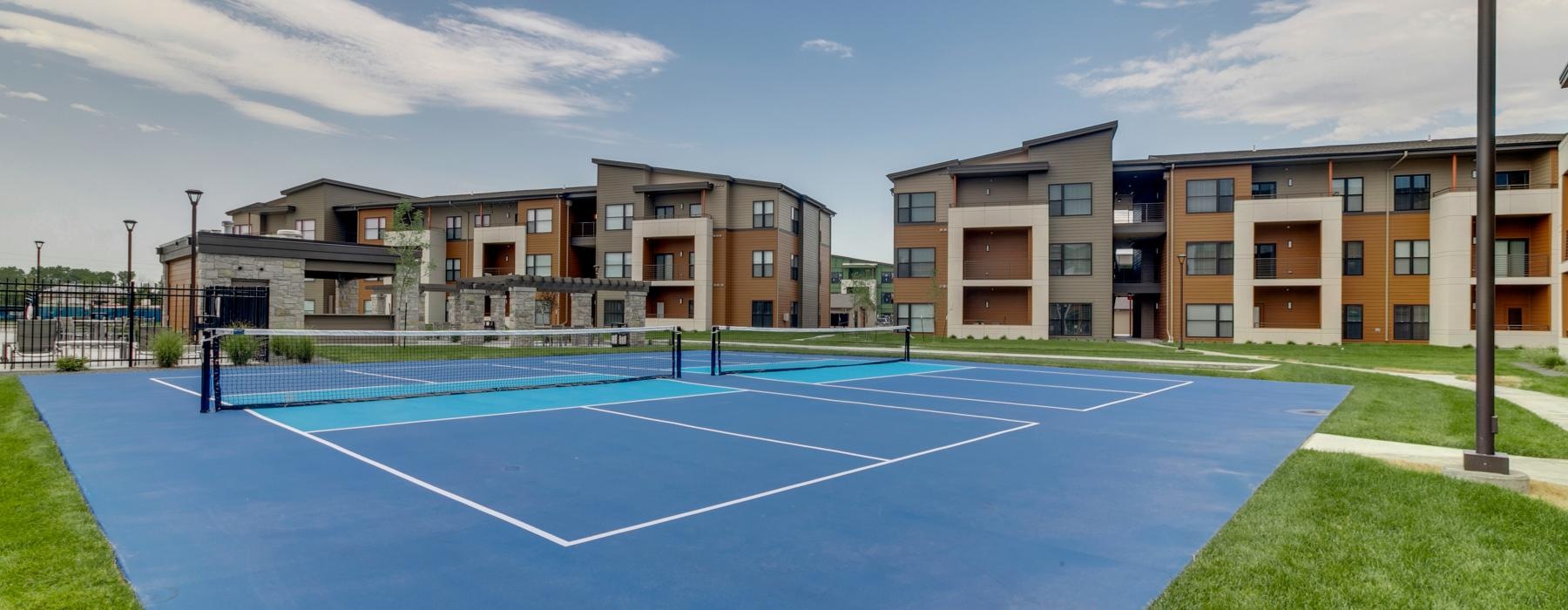 a tennis court with a building in the background